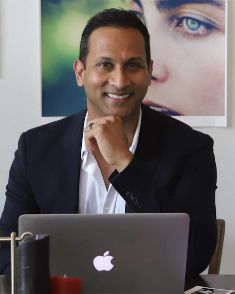 Dr. Tejas Patel at his desk, reflecting the continuing education that builds cosmetic dentistry skills after dental school